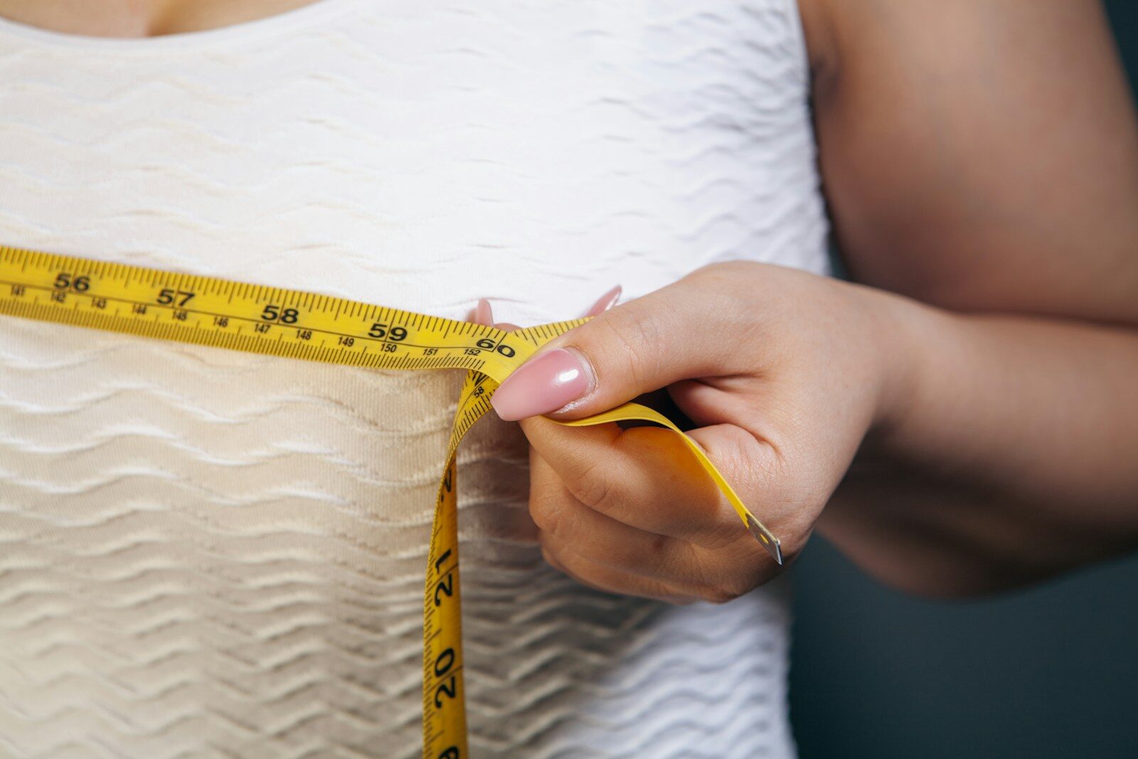 Woman measuring her chest with a tape measure